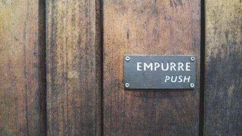 Close-up of text on wooden wall