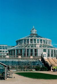 Low angle view of botanic garden building against blue sky, palm house 