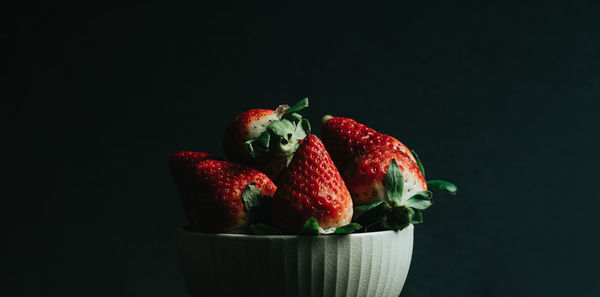 Close-up of strawberries on table against black background