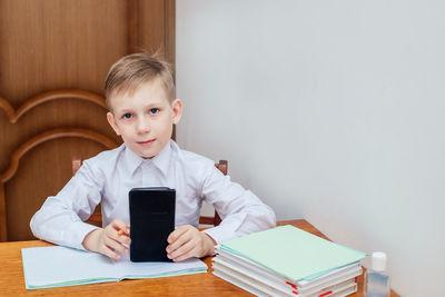 Portrait of boy sitting on table