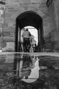 Reflection of people on puddle