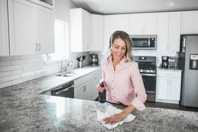 Woman cleaning kitchen counter at home