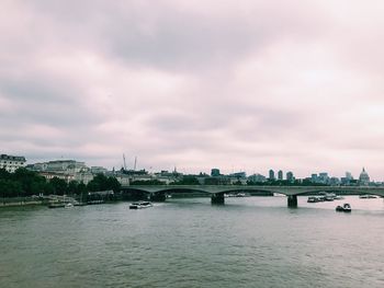 Bridge over river against cloudy sky