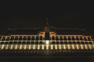 Low angle view of illuminated building against sky at night