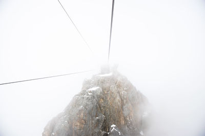 Overhead cable car against sky during foggy weather