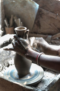 Cropped image of hands making pottery