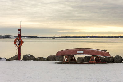 Built structure by river against sky during sunset