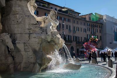 View of fountain against buildings in city