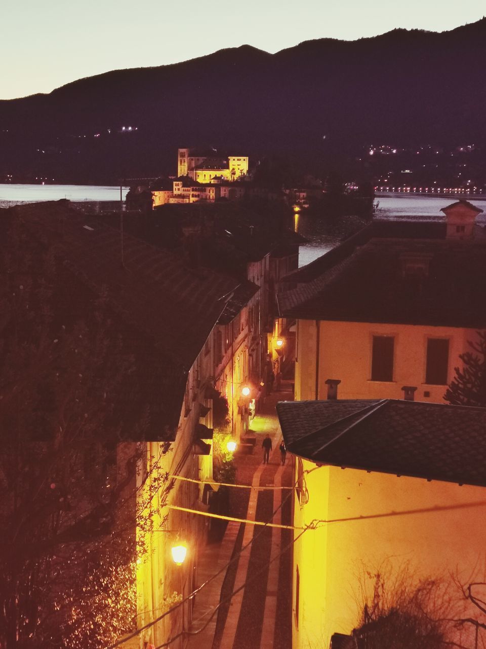 HIGH ANGLE VIEW OF ILLUMINATED BUILDINGS AGAINST SKY AT DUSK