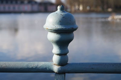 Close-up of metallic railing against lake