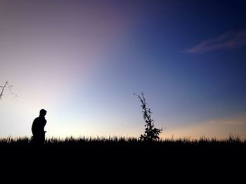 Silhouette man standing on field against clear sky