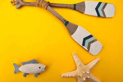 High angle view of toys and oars on yellow background