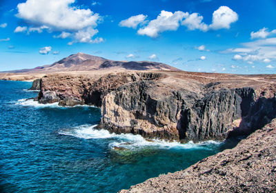 Scenic view of sea and mountains against sky