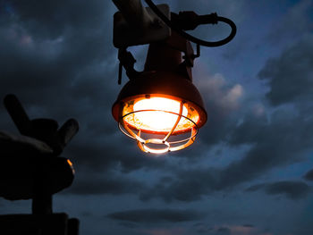 Low angle view of illuminated lamp against sky at sunset