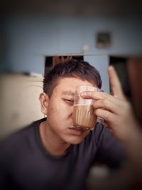 Close-up portrait of a man drinking glass