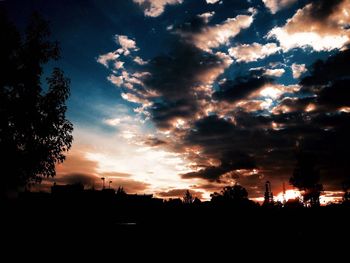 Silhouette of trees against cloudy sky