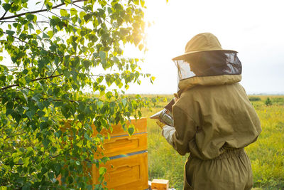 Rear view of man standing against trees