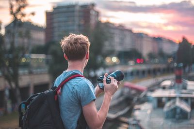 Rear view of man photographing in city