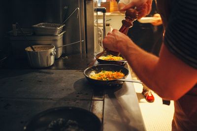 Midsection of man preparing food in kitchen