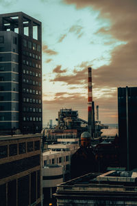Modern buildings against sky during sunset