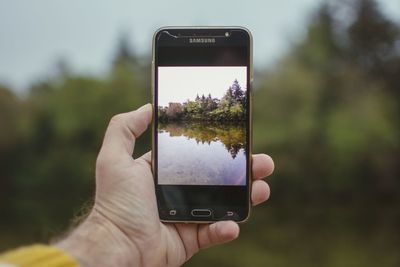 Cropped image of hand holding smart phone