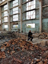 Woman sitting on chair at abandoned building