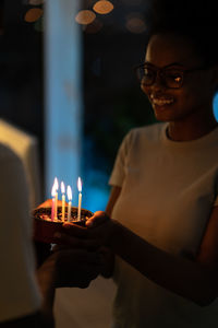 Close-up of man holding lit candle