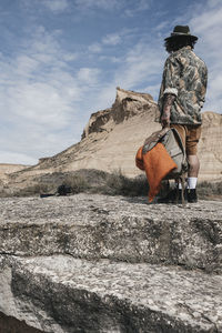 Back view of man on hiking tour to discover wild lands on vacation, man with wanderlust standing 