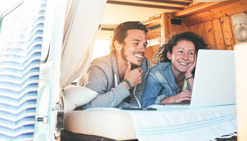 Happy couple using laptop in motor home