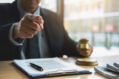 Midsection of man holding coffee cup on table