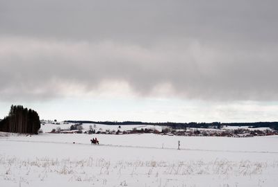 Scenic view of snow covered field against sky