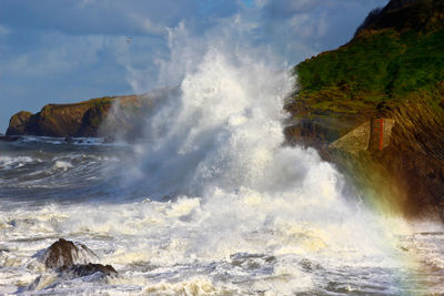 Waves splashing on sea against sky