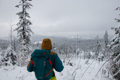 Side view of woman standing on snow covered landscape