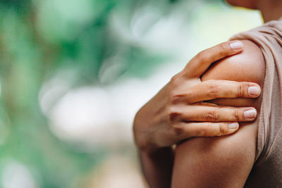 Close-up of woman touching finger against blurred background