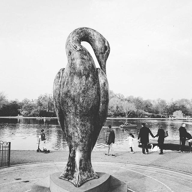 water, animal themes, bird, animals in the wild, wildlife, clear sky, lake, day, river, pigeon, outdoors, duck, built structure, perching, nature, full length, standing, sculpture, one animal, animal representation