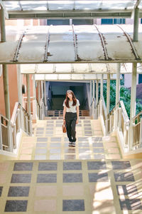 Portrait of woman on staircase against building