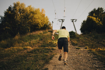 Rear view of sportsman running on land