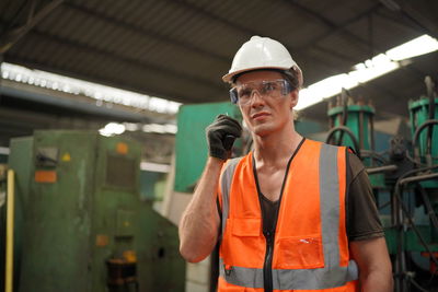 Portrait of young man standing in factory