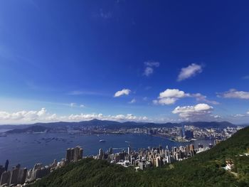 Panoramic view of sea and buildings against blue sky