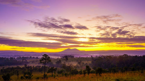 Scenic view of dramatic sky over landscape during sunset