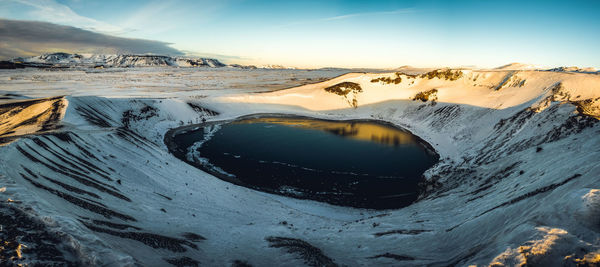 Scenic view of snowcapped volcanic crater against sky during sunset