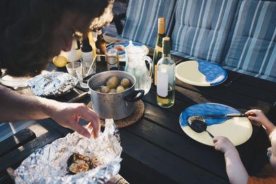 Father serving food to daughter at table in holiday villa