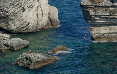 High angle view of people on rock at sea