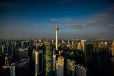 Aerial view of buildings in city against cloudy sky