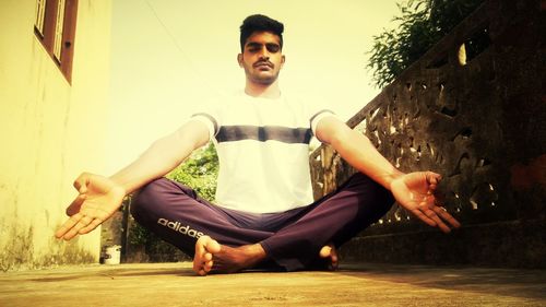 Young man sitting on wall