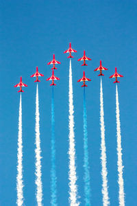 Low angle view of airplane flying against clear blue sky