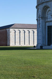 Built structure against clear sky with lawn in foreground