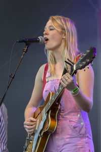 Midsection of woman playing guitar