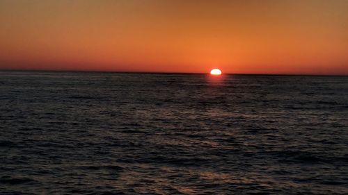 Scenic view of sea against orange sky