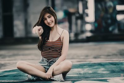 Young woman using mobile phone while sitting outdoors